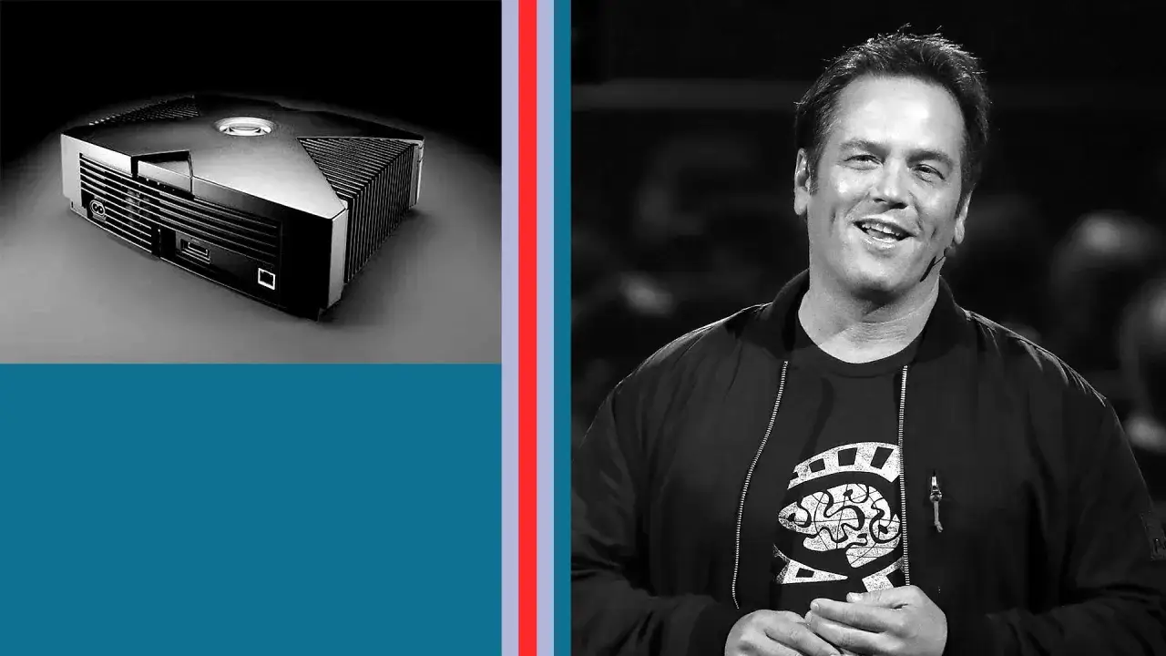Phil Spencer sonríe junto a la icónica Xbox original, un símbolo de su legado en los videojuegos.