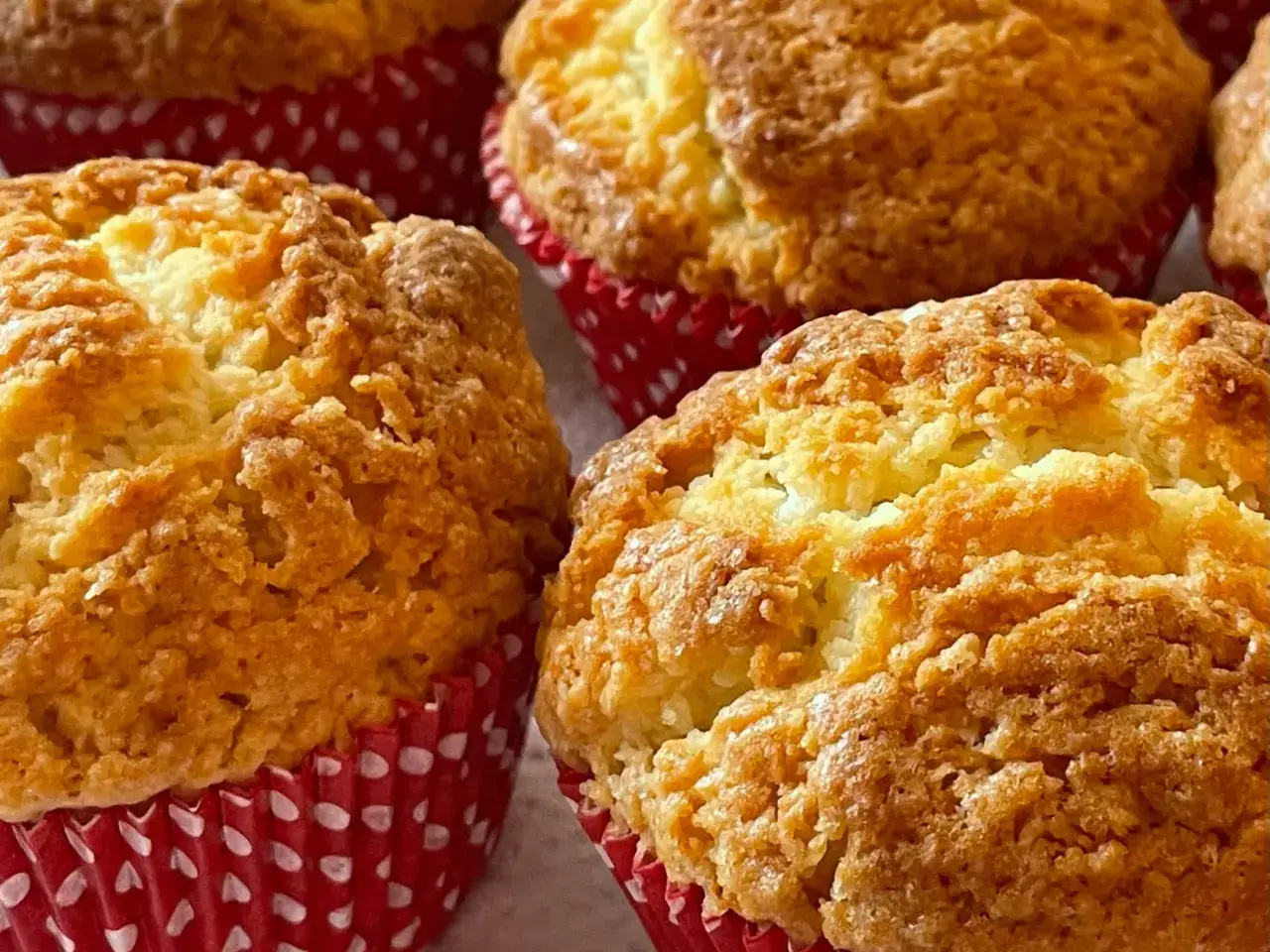 Złociste muffinki w czerwonych papilotkach z białymi kropkami. Idealne na szybki przepis na muffinki.