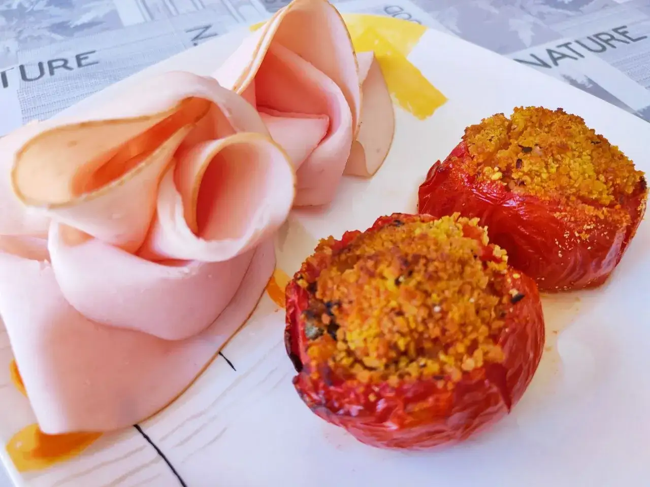 Deliziosi pomodori ripieni in friggitrice ad aria, serviti con fette di prosciutto cotto arrotolate.