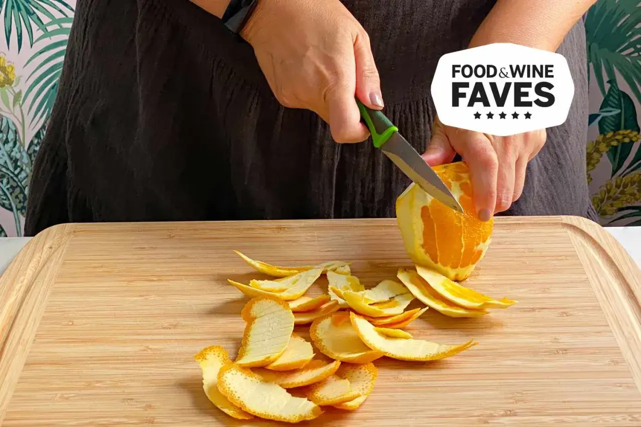 Manos pelando una naranja con un cuchillo puntilla, ideal para trabajos de precisión en la cocina.