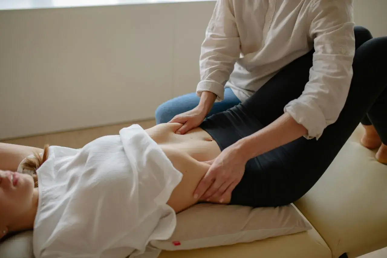 Fizjoterapeuta masuje brzuch pacjentki, co może pomóc zidentyfikować, od czego może boleć przepona.