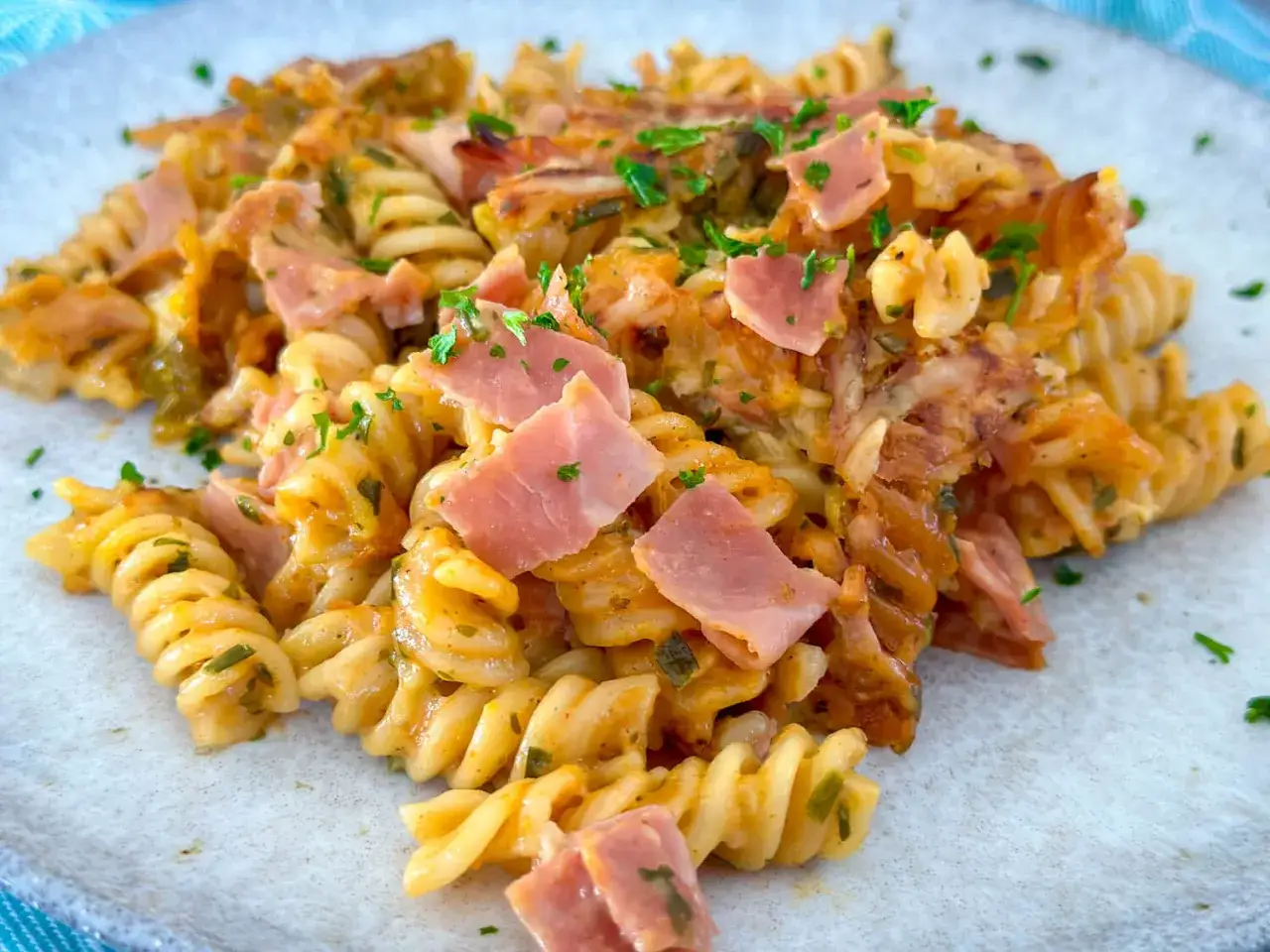 Ein k&ouml;stlicher Nudel Schinken Auflauf mit Spiralnudeln, Schinkenw&uuml;rfeln und K&auml;se &uuml;berbacken, garniert mit frischer Petersilie.