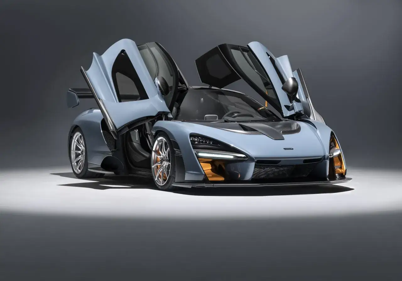 Niebieski McLaren Senna z otwartymi drzwiami, gotowy do startu.