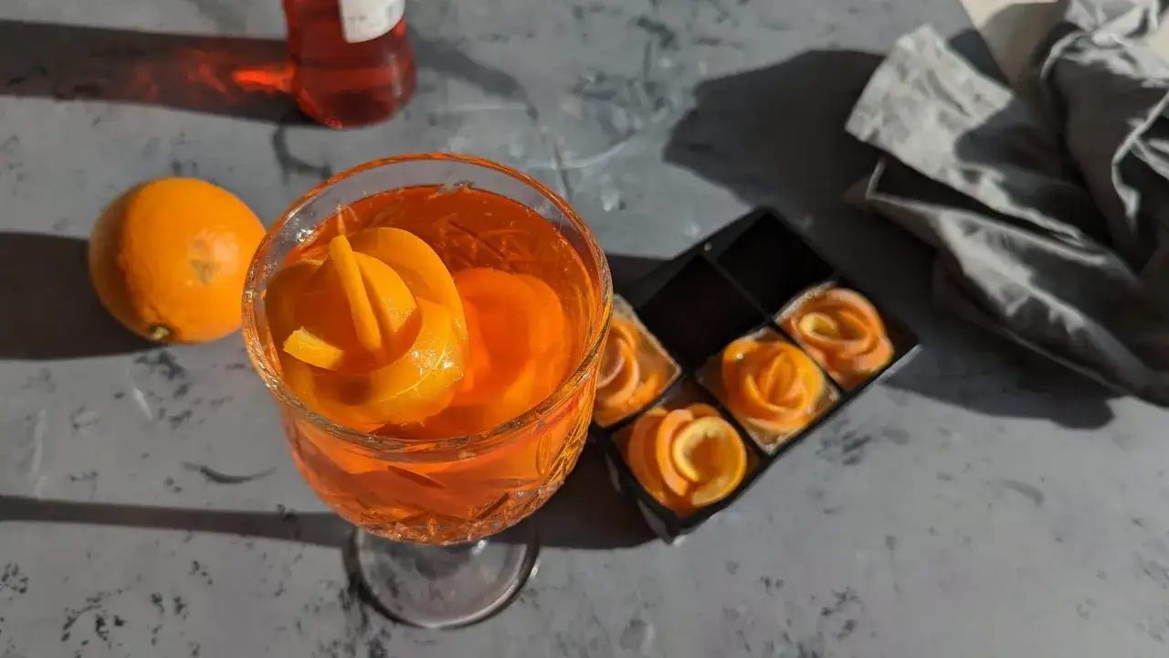 Ein Aperol Spritz mit Orangenscheiben und Eiswürfeln. Der Aperol alkoholgehalt ist moderat, perfekt für einen Sommerabend.