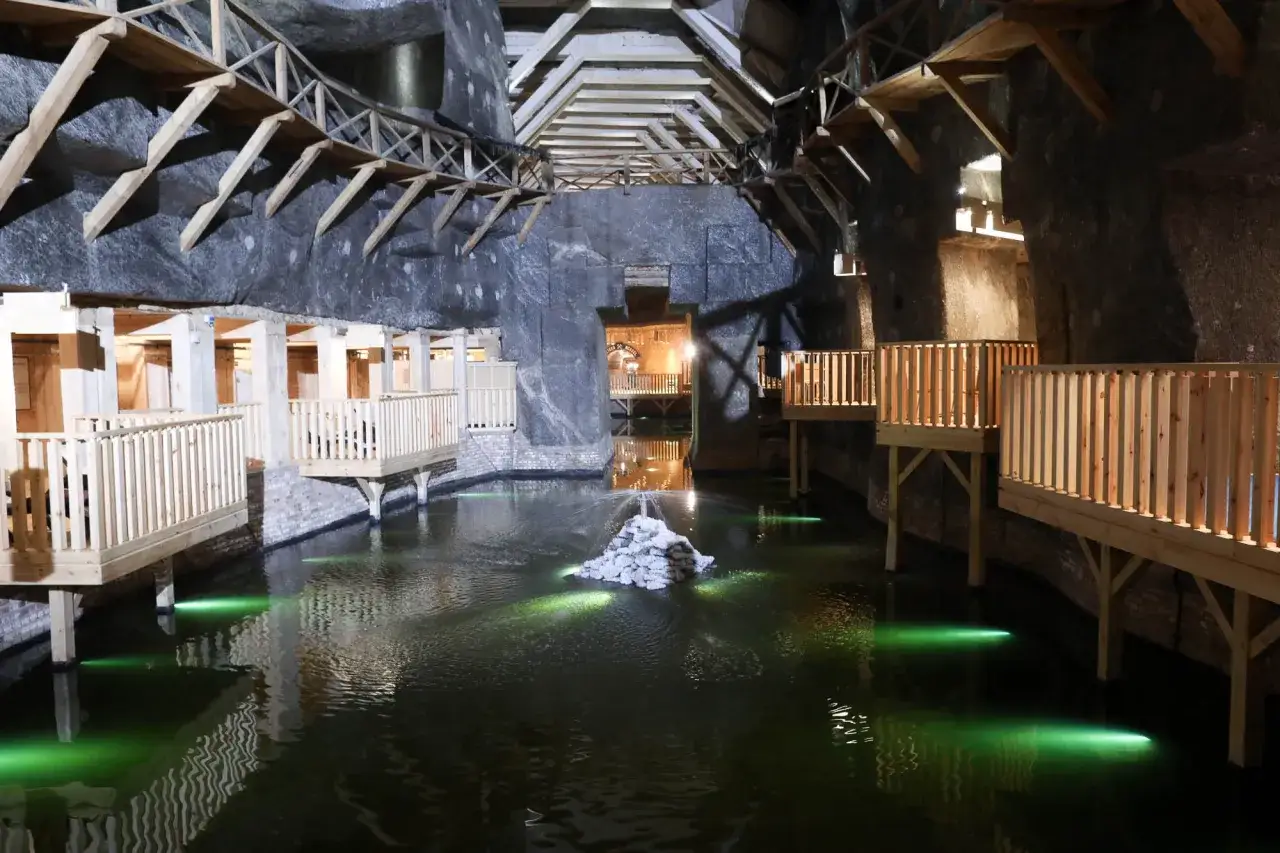 Podziemne jezioro w kopalni soli. Drewniane kładki i oświetlenie tworzą magiczną atmosferę. Idealne miejsce na zakup wieliczka bilety.