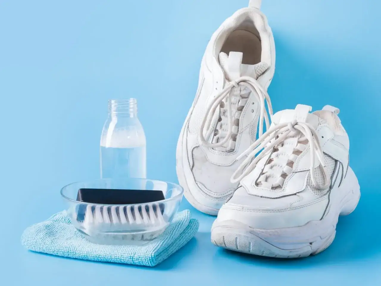 Weiße Laufschuhe werden mit Bürste und Seife gewaschen.