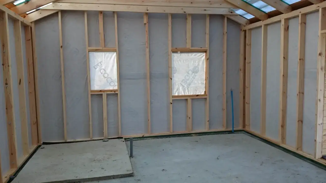 Wnętrze budowy domków drewnianych całorocznych pod klucz. Ceny zależą od wykończenia. Widoczne szkielety ścian, okna i instalacje.