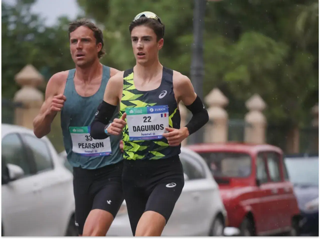 Le coureur Étienne Daguinos, dossard 22, en pleine course, concentré malgré la pluie.