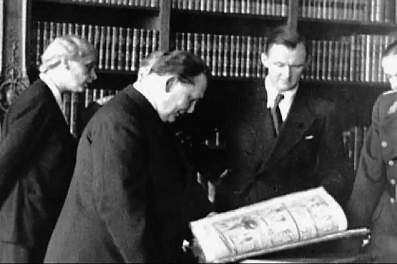 Bruno Lohse et d'autres hommes examinant un livre ouvert dans une bibliothèque.