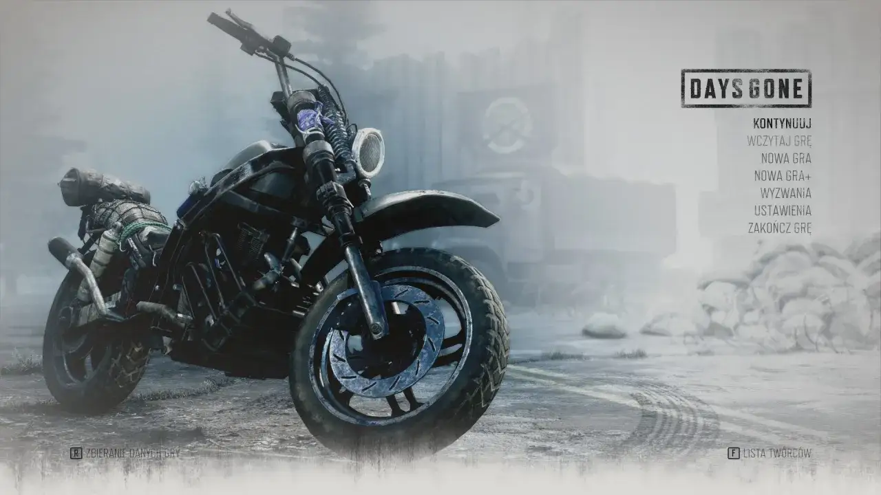 Motocykl z gry Days Gone, gotowy na kolejną przygodę. Menu gry oferuje opcje: kontynuuj, nowa gra, wyzwania.