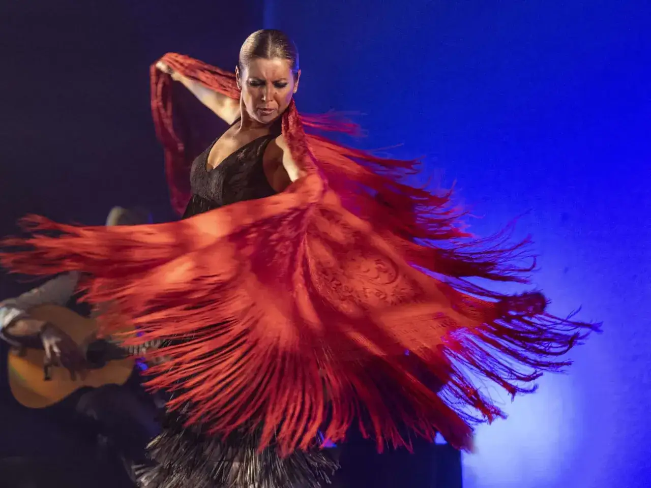 Sara Baras, en plena actuaci&oacute;n, despliega un mant&oacute;n rojo vibrante. Su edad se refleja en la maestr&iacute;a de su baile flamenco.
