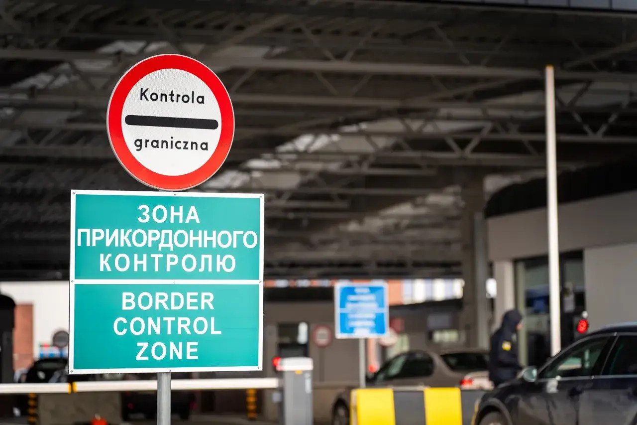 Znaki informują o strefie kontroli granicznej. Samochody czekają na przejściu granicznym.