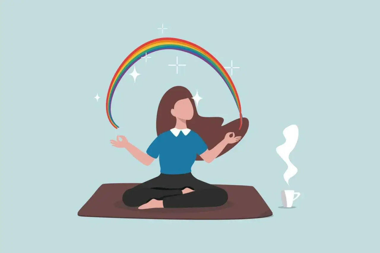 En person sitter i meditationsställning med en regnbåge över huvudet. En kopp med ånga står bredvid. Perfekt för en meditation 10 min.