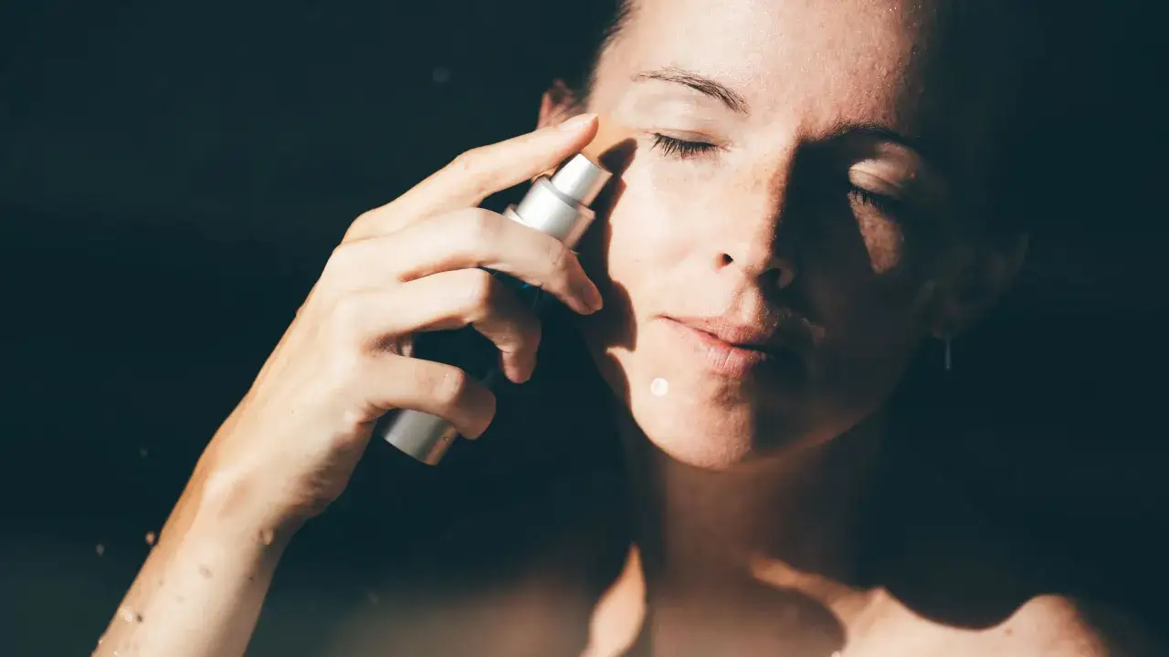 Kobieta aplikuje kosmetyk na twarz. Czy to retinol? Co to jest retinol i jak działa na skórę?