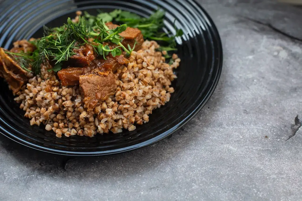 Un plat réconfortant de blé noir garni de morceaux de viande mijotée et d'herbes fraîches.