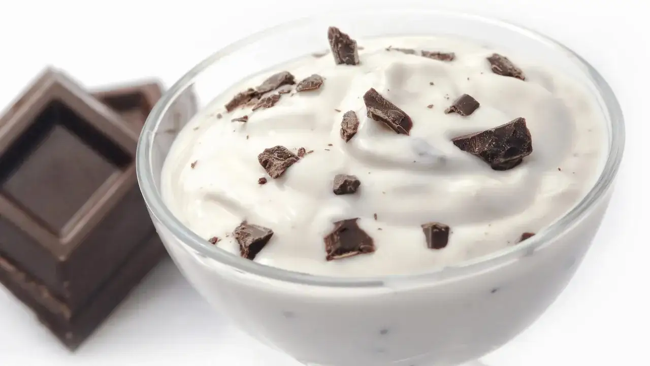 Cremige Herrencreme mit Schokoladenst&uuml;ckchen im Glas, daneben ein St&uuml;ck dunkle Schokolade. Ein einfaches Herrencreme Rezept.