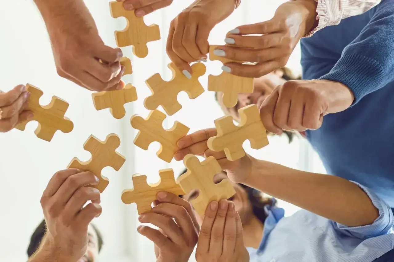 Zesp&oacute;ł składa puzzle, symbolizując wsp&oacute;łpracę i realizację obowiązk&oacute;w kierownika.
