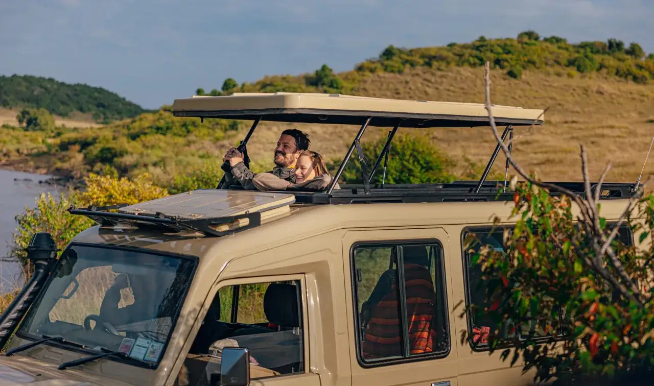 Para w safari w Kenii w grudniu, ciesząca się piękną pogodą i krajobrazem.
