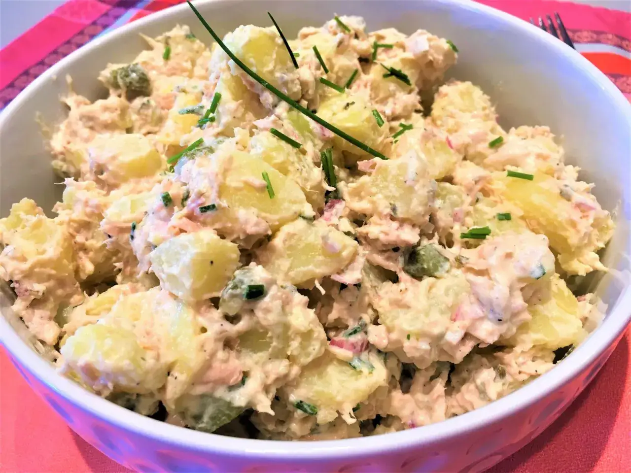 Salade de pommes de terre et thon crémeuse, garnie de ciboulette fraîche. Un délice simple et savoureux.