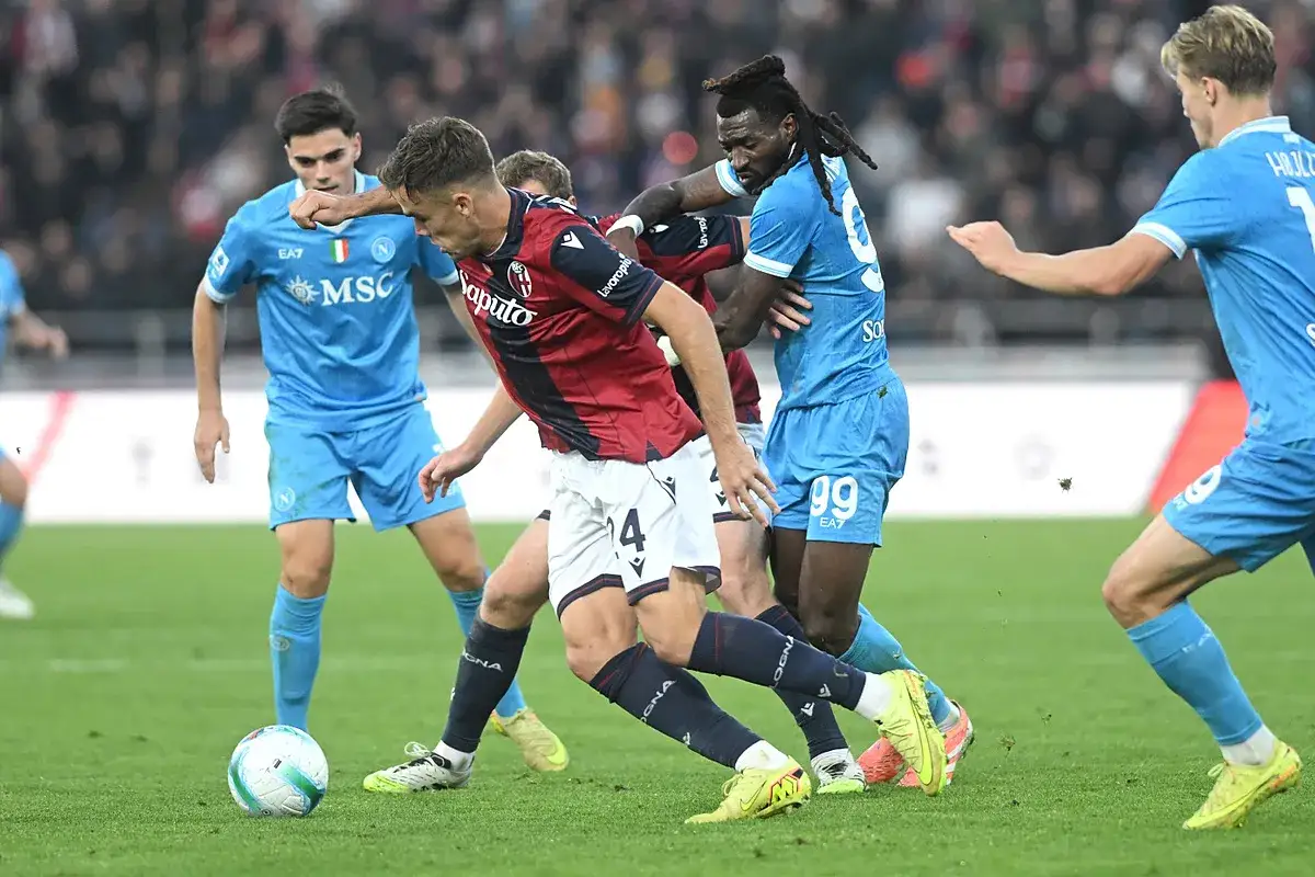 Piłkarze Bologna FC 1909 i Napoli walczą o piłkę na boisku.