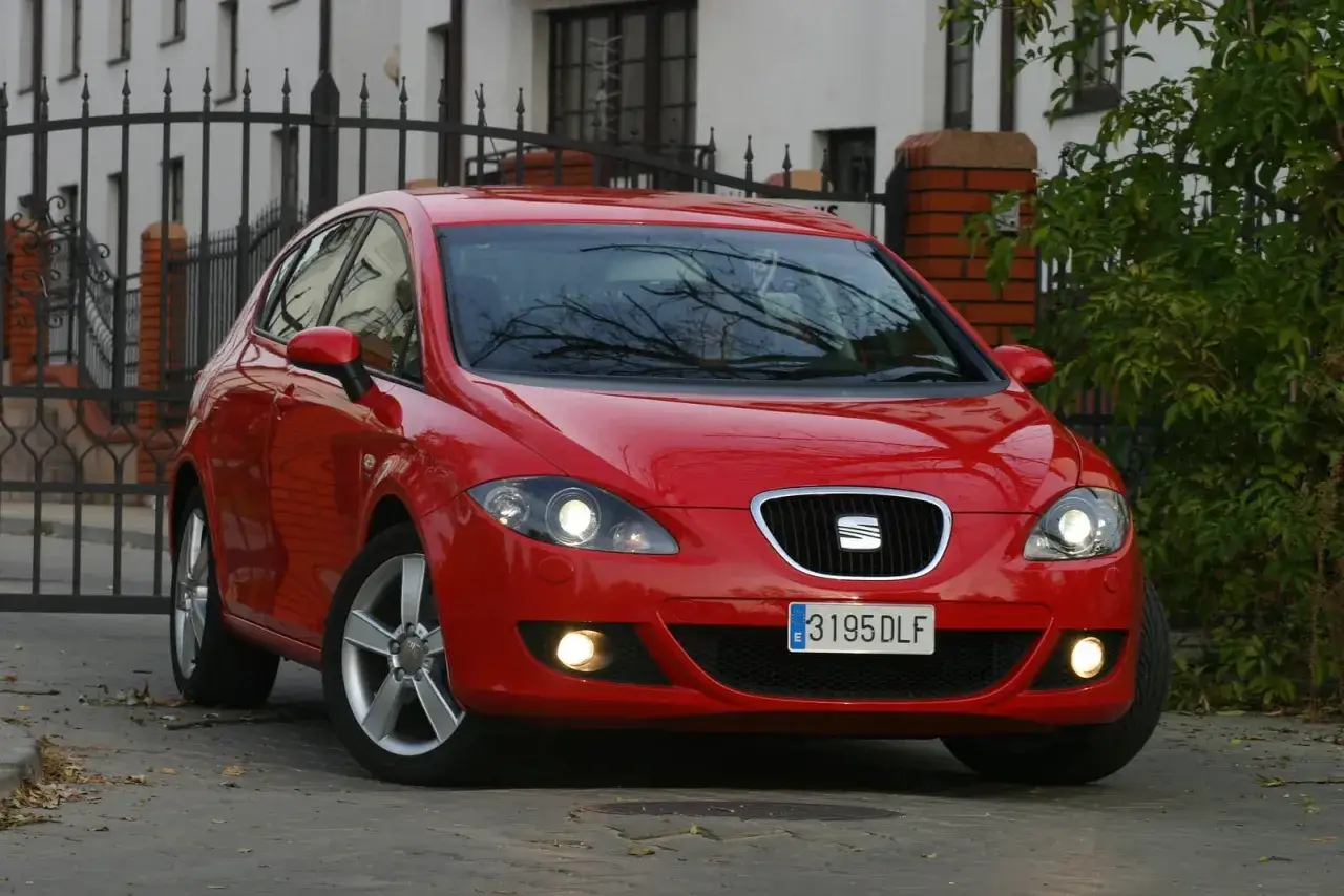 Czerwony Seat Leon 2 przed wymianą żarówki w przednim reflektorze.