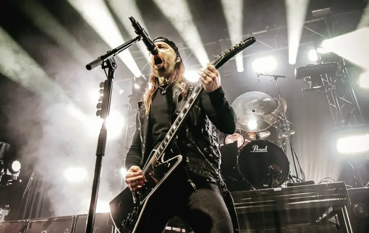 Matt Tuck de Bullet For My Valentine, en plein concert, guitare en main, sous les projecteurs. L'énergie de leurs albums live.