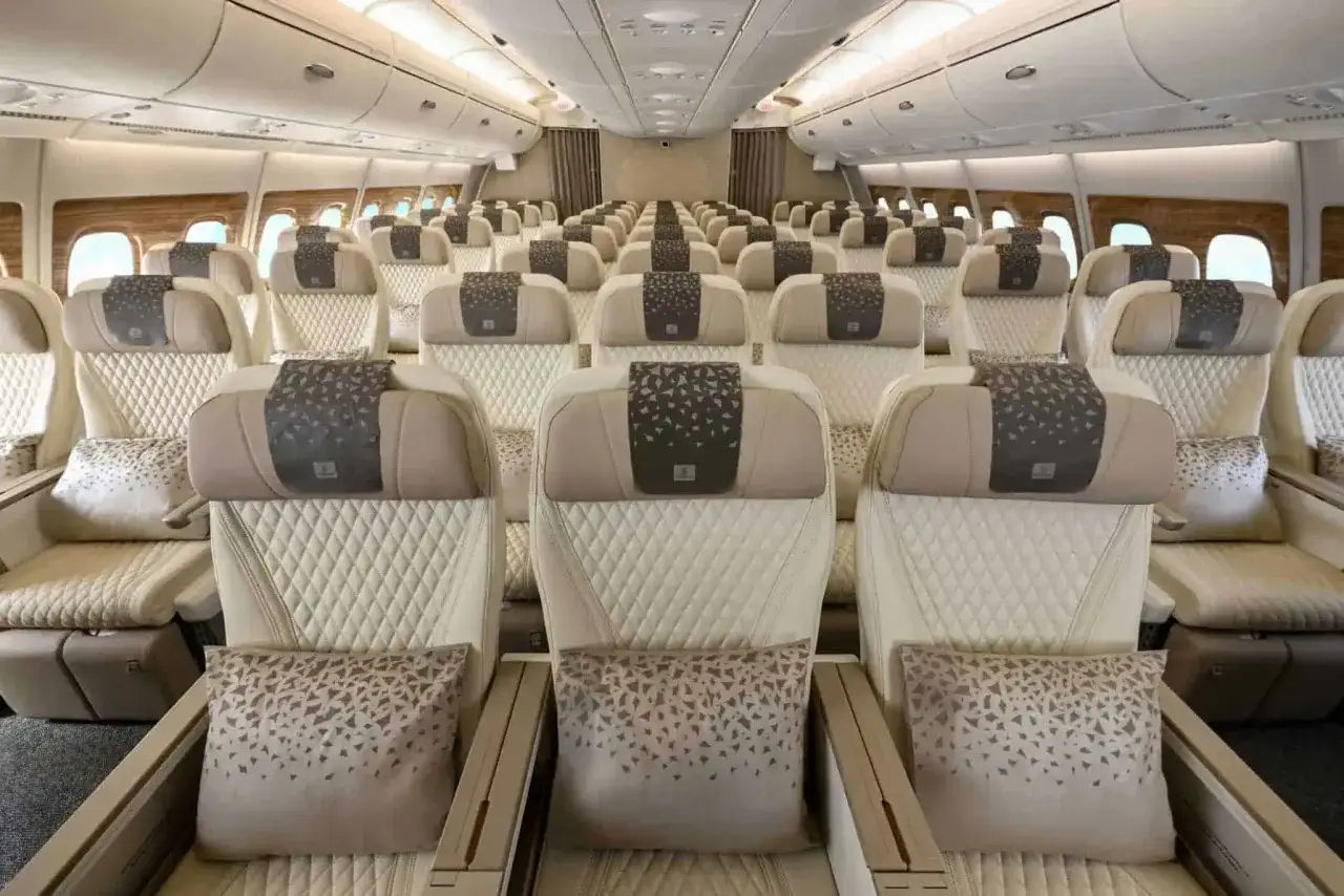 Wnętrze Airbus A380 z rzędami luksusowych, kremowych foteli. Ile miejsc? Ten gigantyczny samolot oferuje ich setki, zapewniając komfort podróży.