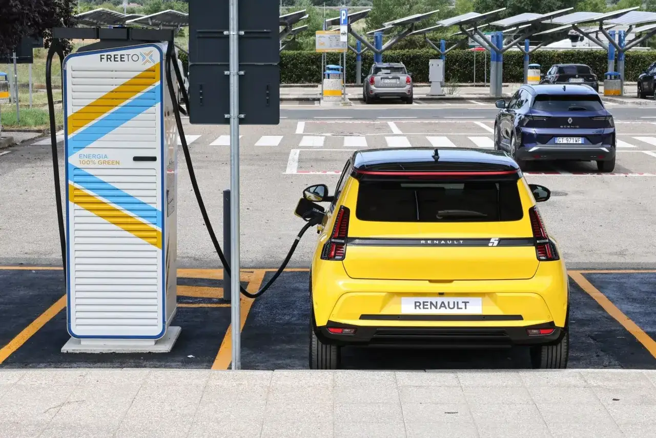 Auto elettriche Italia: una Renault gialla in carica presso una colonnina 