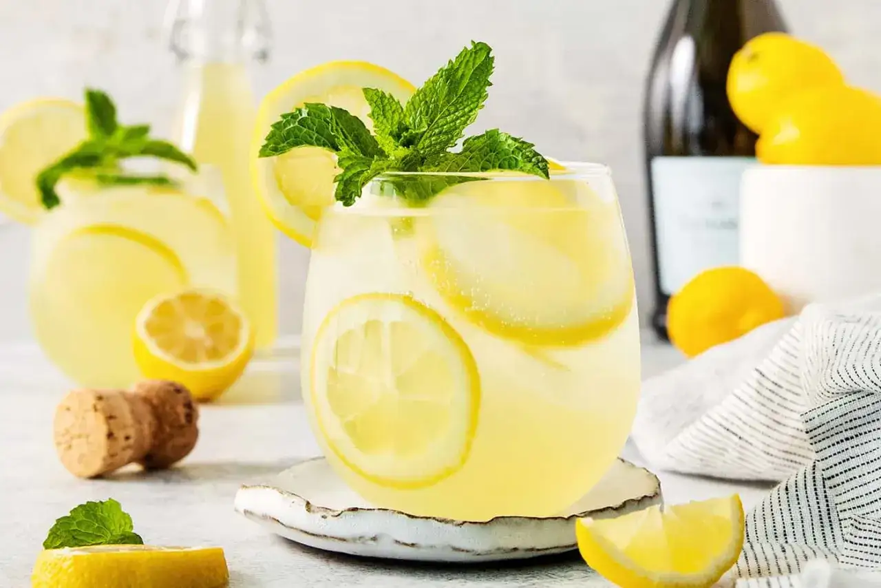 Orzeźwiający limoncello spritz z plasterkami cytryny i miętą, idealny na letnie popołudnie.
