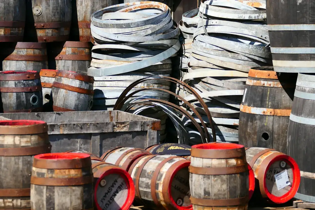 Stare beczki i obręcze, przypominające o tym, czy whisky może dojrzewać w butelce – mit o starzeniu po zakupie.