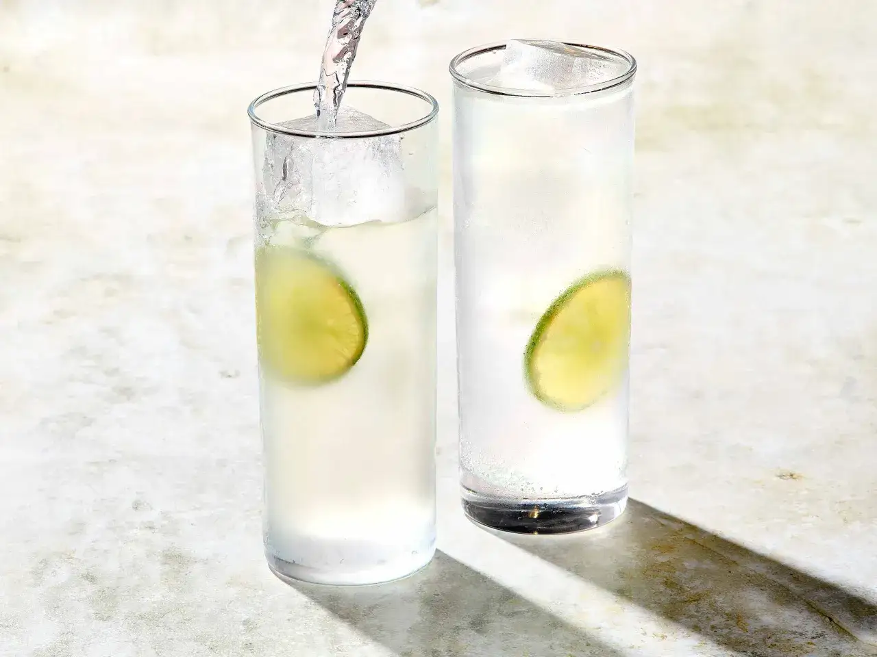 Dwa orzeźwiające drinki z wódką, lodem i plasterkiem limonki, gotowe do podania.