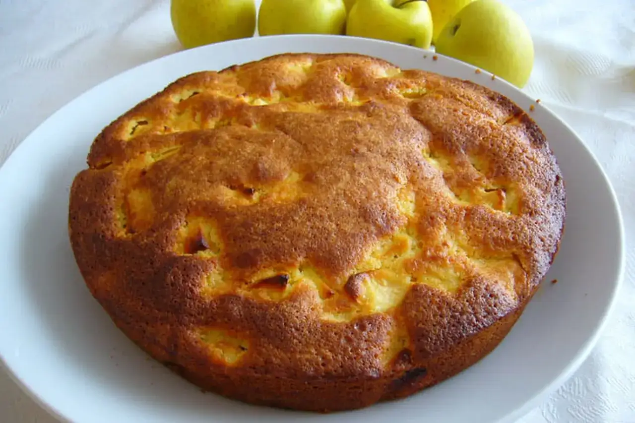 Gâteau aux pommes doré, un délice sans sucre. Des morceaux de fruits sont visibles à travers la croûte.