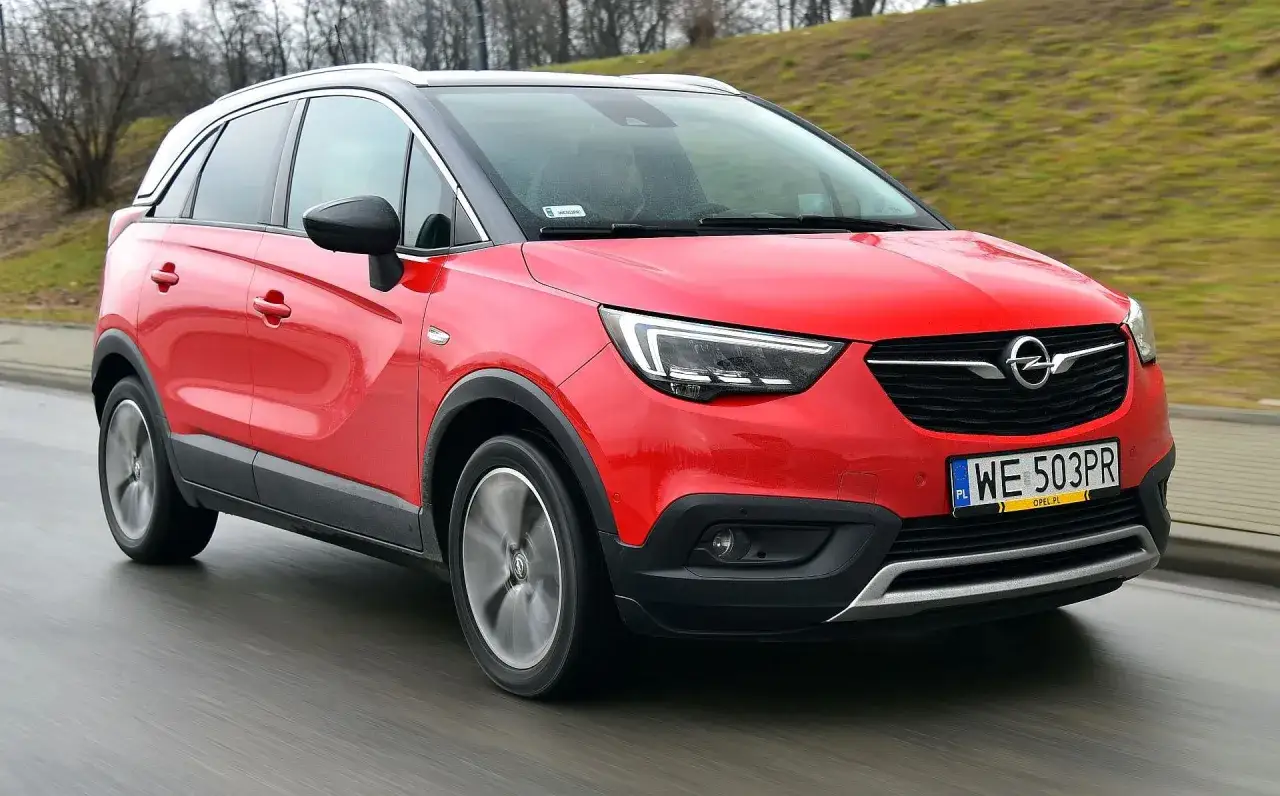 Czerwony Opel Grandland w ruchu. Czy warto go kupić? Sprawdź opinie na forum!