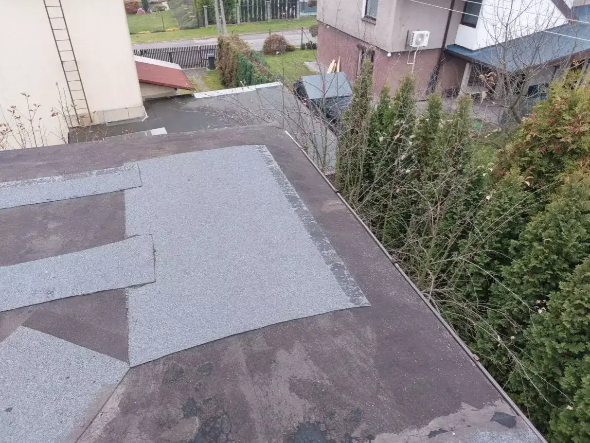 Ocieplenie dachu płaskiego pokrytego papą. Nowe warstwy izolacji widoczne na powierzchni.