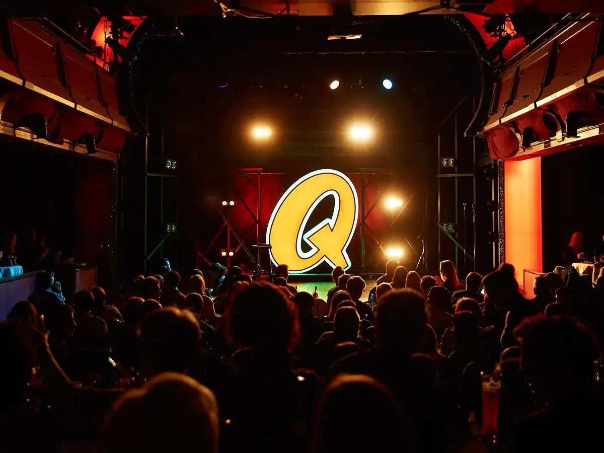 Publikum im Scheinwerferlicht, bereit für Comedy in Berlin. Ein großes gelbes