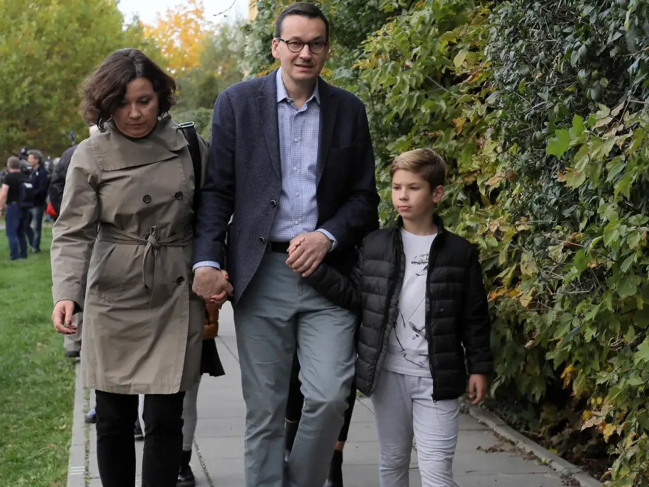 Mateusz Morawiecki z żoną i dziećmi spaceruje alejką.