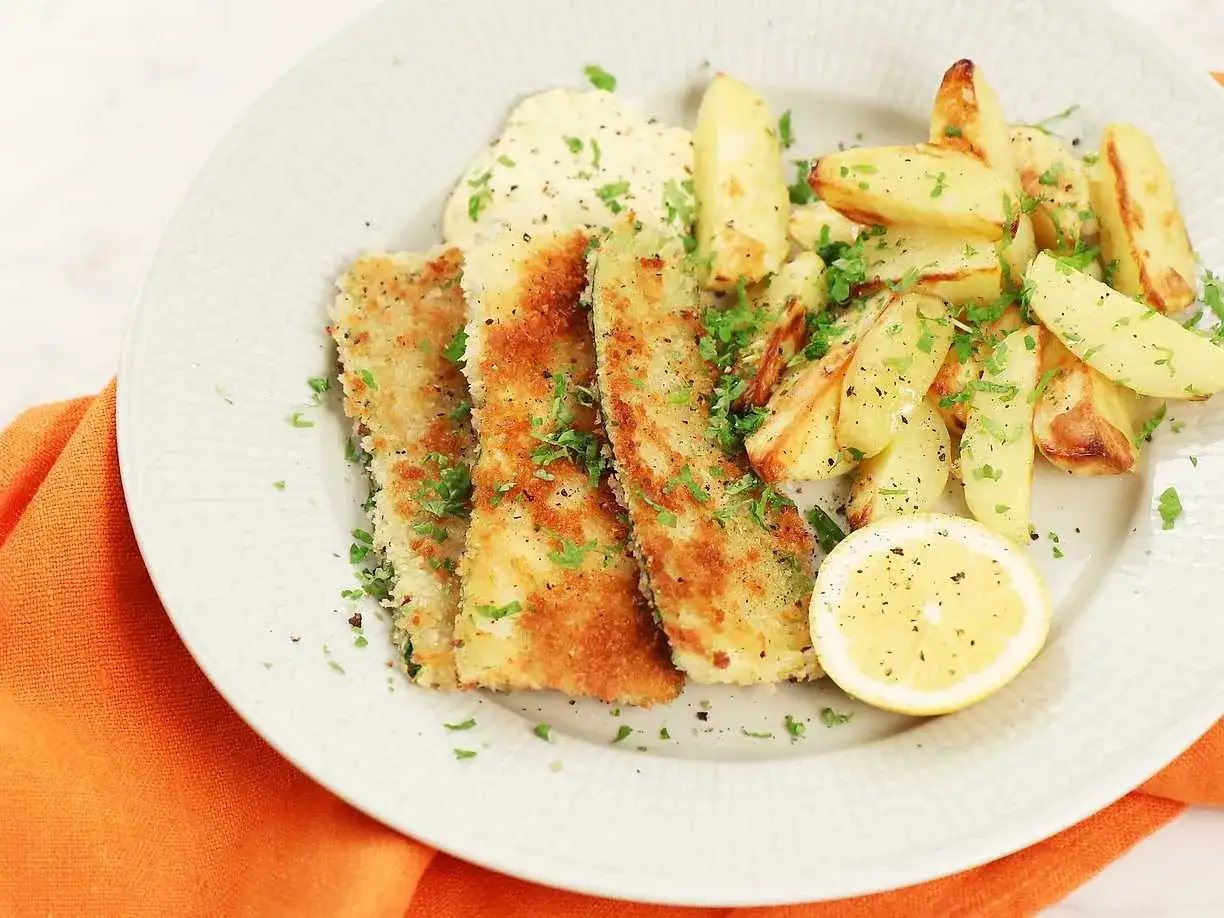 Krispigt friterad zucchini med pommes frites, en klick s&aring;s och en citronskiva.
