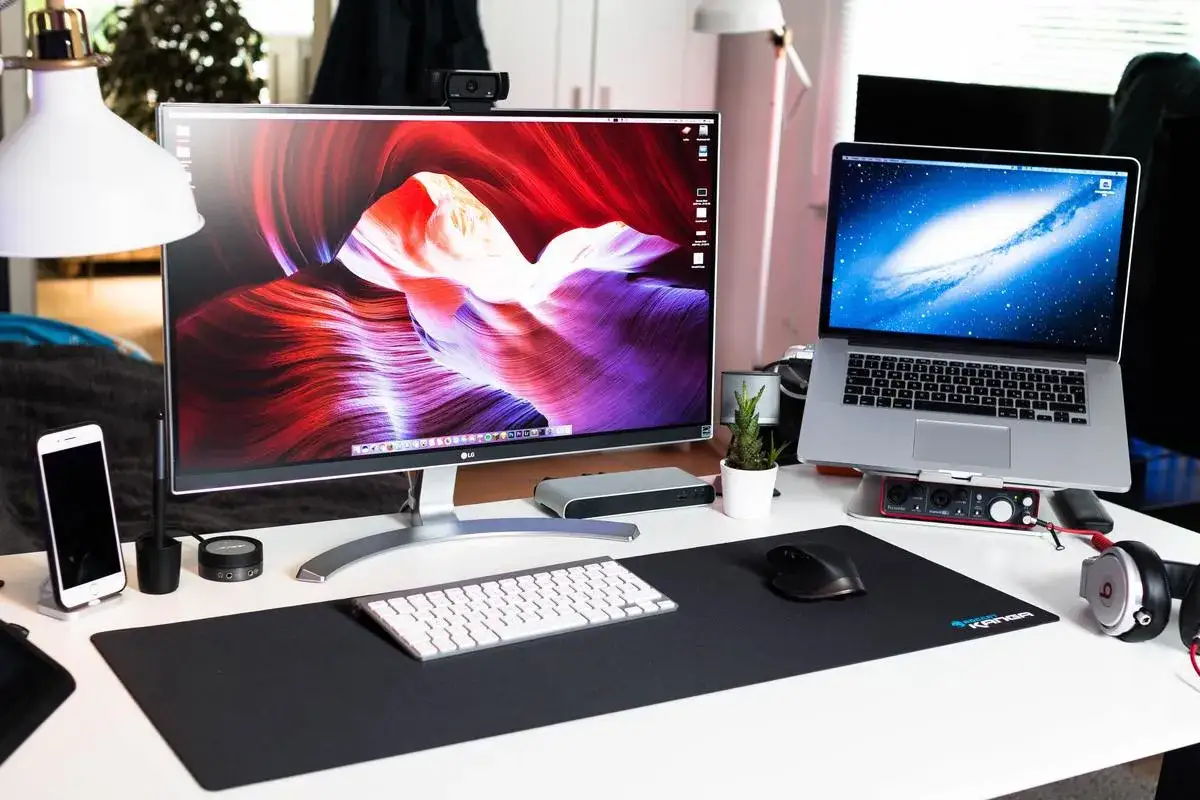 Stacja robocza z dwoma monitorami, laptopem i akcesoriami. Dowiedz się, jak podłączyć dwa monitory do laptopa, aby zwiększyć produktywność.