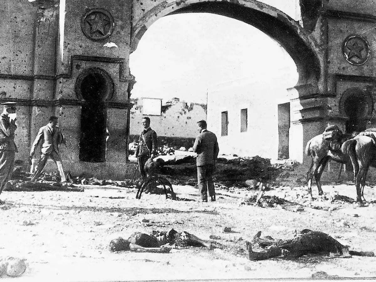 Ruinas y cuerpos en el suelo bajo un arco. Hombres y caballos observan la escena, quizás tras un evento relacionado con Alfonso V de Portugal.