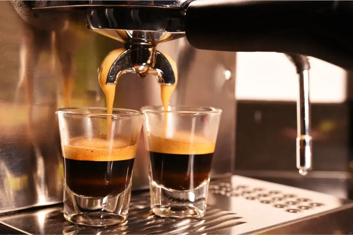 Zwei Gläser werden mit frisch gebrühtem Espresso gefüllt. Die Crema ist perfekt, eine wahre Espresso-Definition.