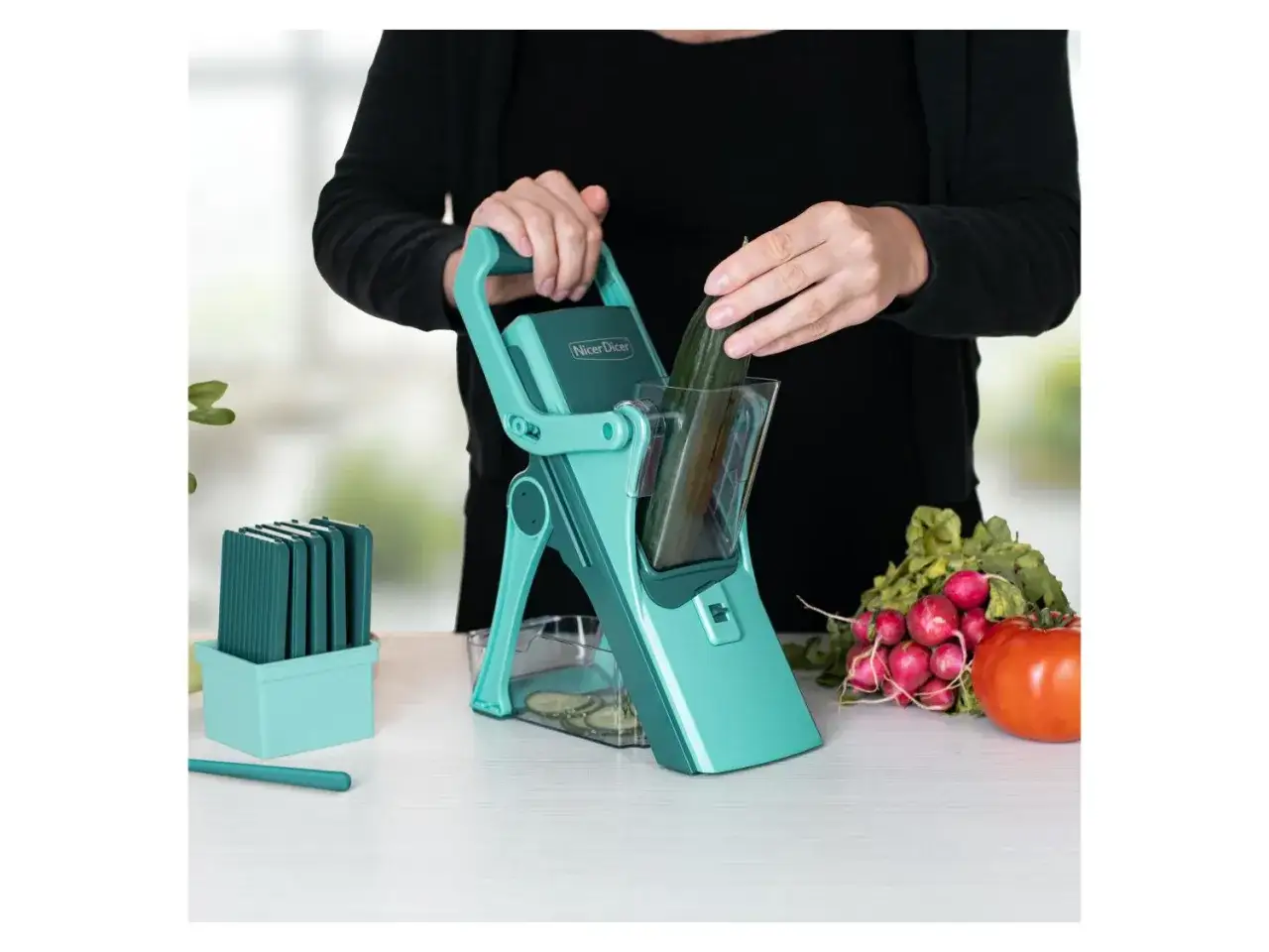 Ein Nicer Dicer schneidet Gurken und Gemüse für Salate. Hier wird eine Gurke vorbereitet.