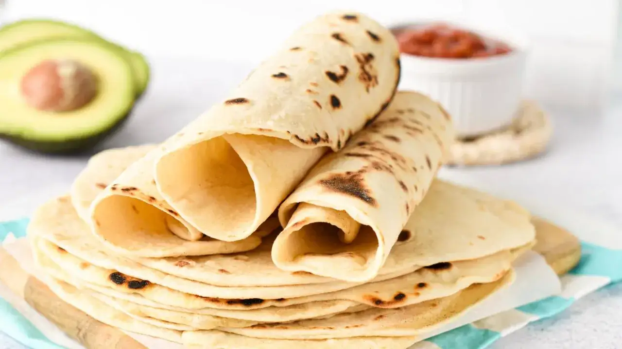 En h&ouml;g med nygr&auml;ddade tortillas, med en halv avokado och en sk&aring;l salsa i bakgrunden. Undrar du cuantas calorias tiene una tortilla?