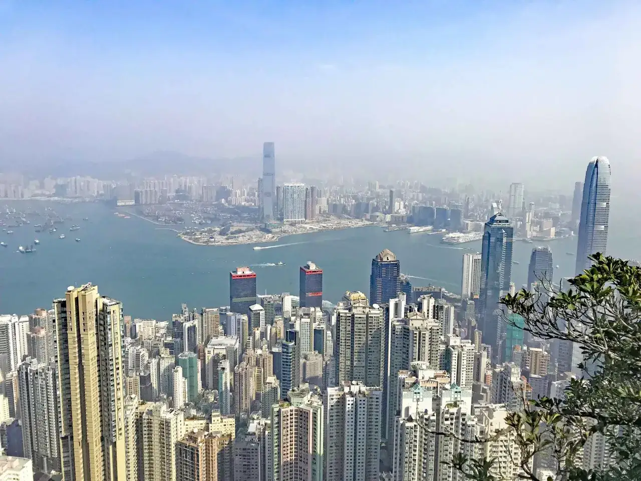 Blick &uuml;ber die Skyline von Hongkong mit dem Hafen und vielen Schiffen. Ein perfekter Ausblick f&uuml;r den Hongkong Urlaub.