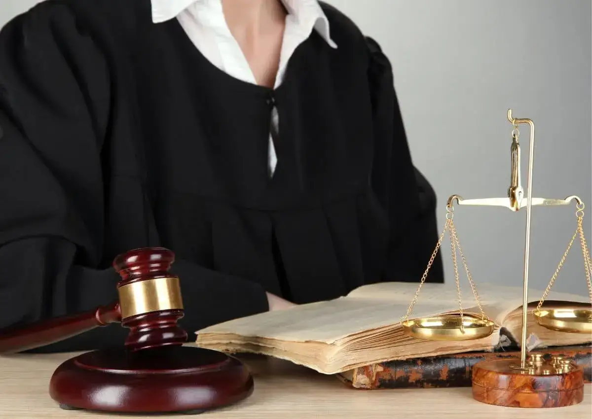 Sędzia w todze, młotek, waga sprawiedliwości i księgi. Czy po uprawomocnieniu wyroku można się odwołać?