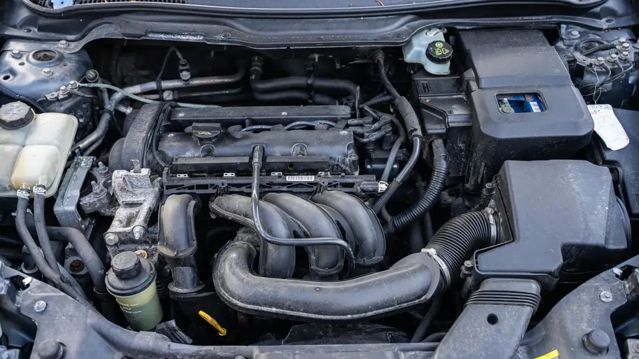 Silnik diesla Volvo V50 2.0d, widok z góry. Widać kolektor dolotowy, akumulator i płyny.