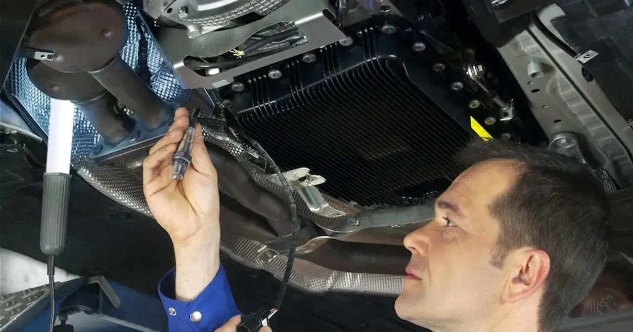 Mechanik sprawdza sondę lambda, potencjalną przyczynę zbyt ubogiej mieszanki.