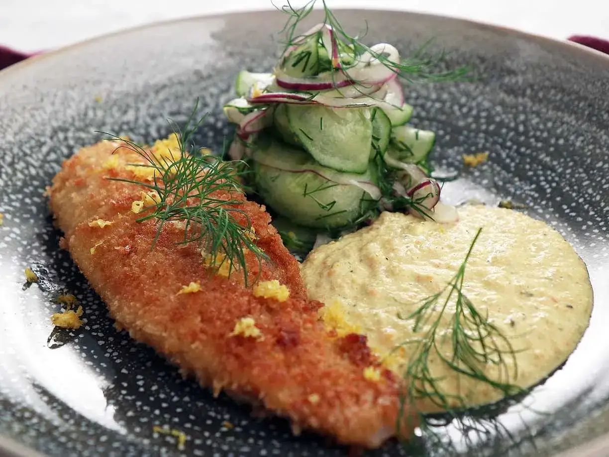 Panerad fisk med en krämig remouladsås curry, gurksallad och dill.