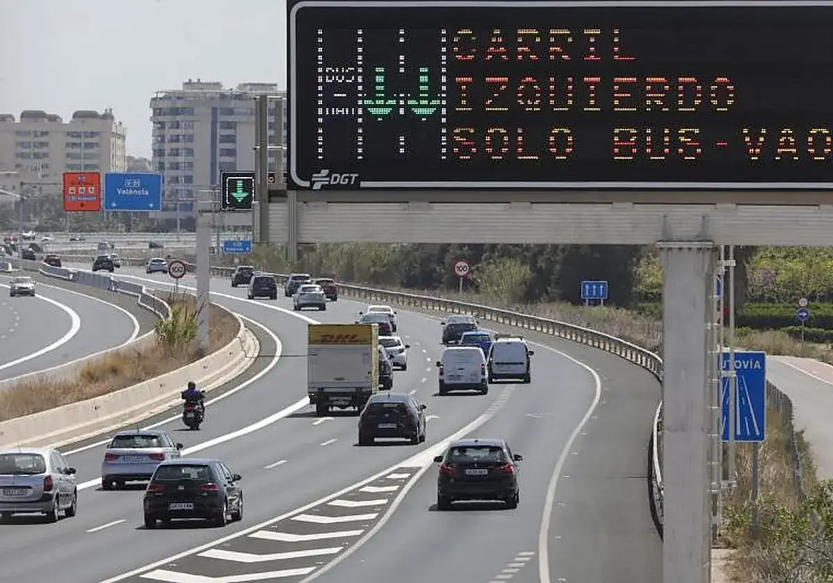 Carril izquierdo solo bus-VAO. Señalización de tráfico en autopista con varios carriles y vehículos.