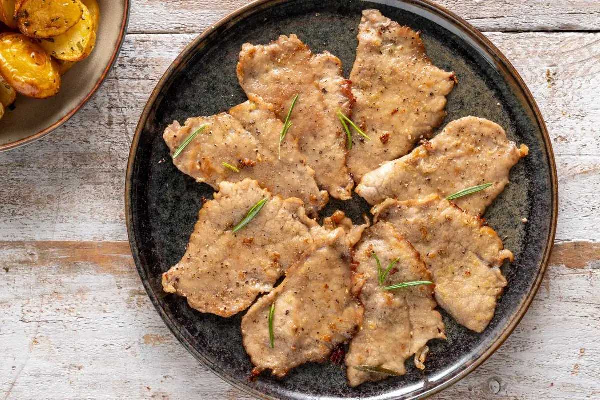 Deliziosi secondi di carne da preparare in anticipo, conditi con pepe e rosmarino, pronti per essere gustati con patate arrosto.