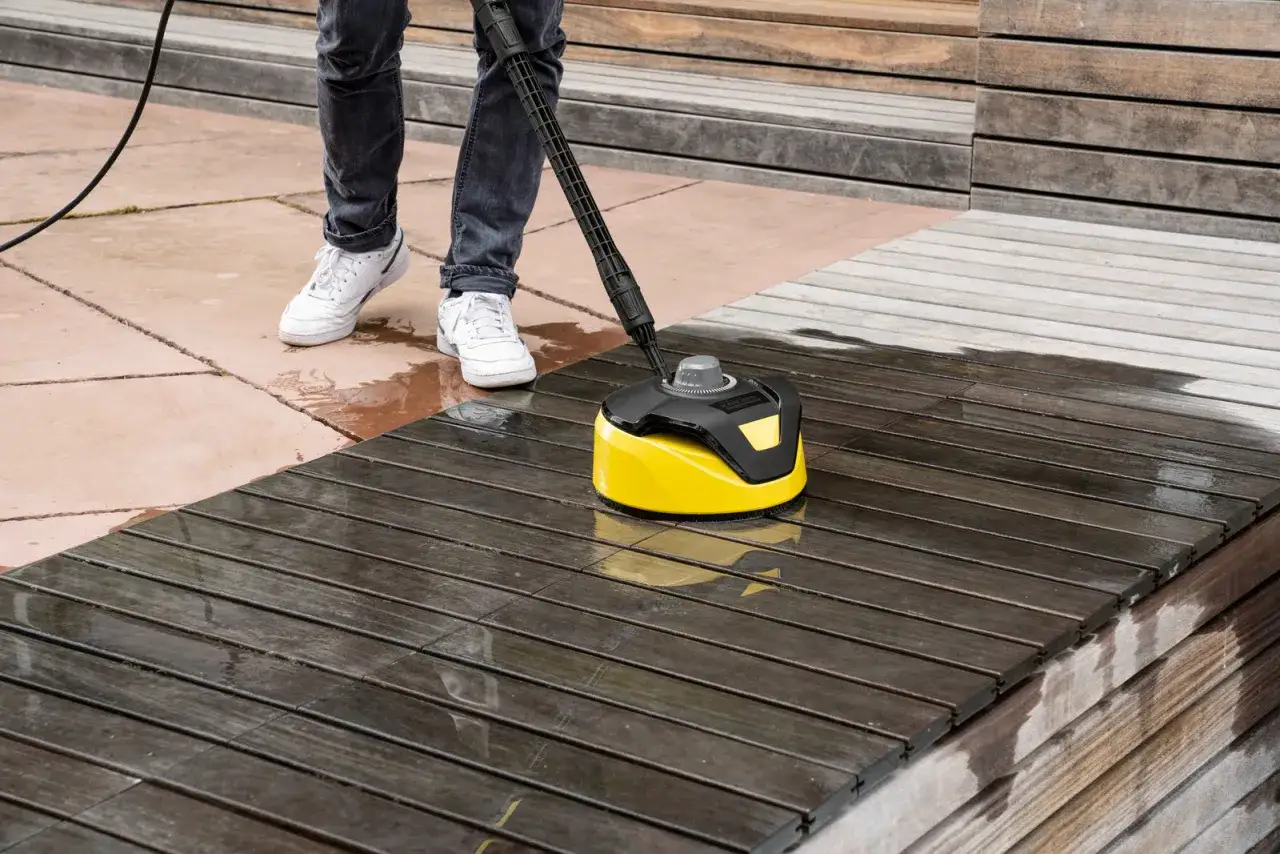 En person använder en K4 power control för att rengöra en träaltan.